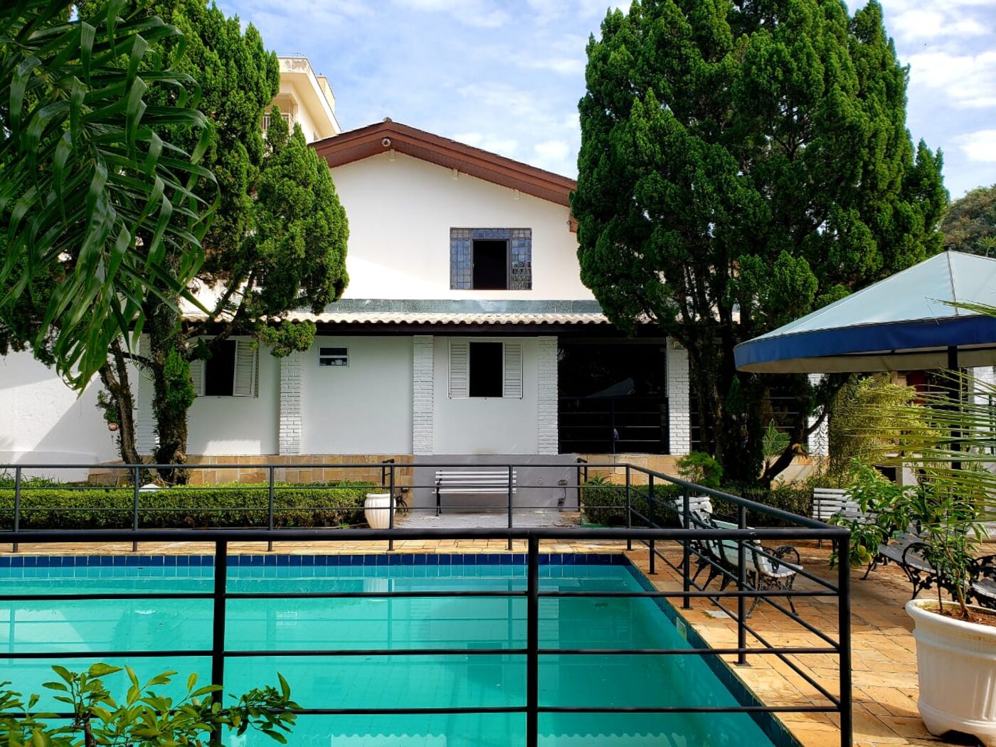 Fundos da casa com piscina e área de estar