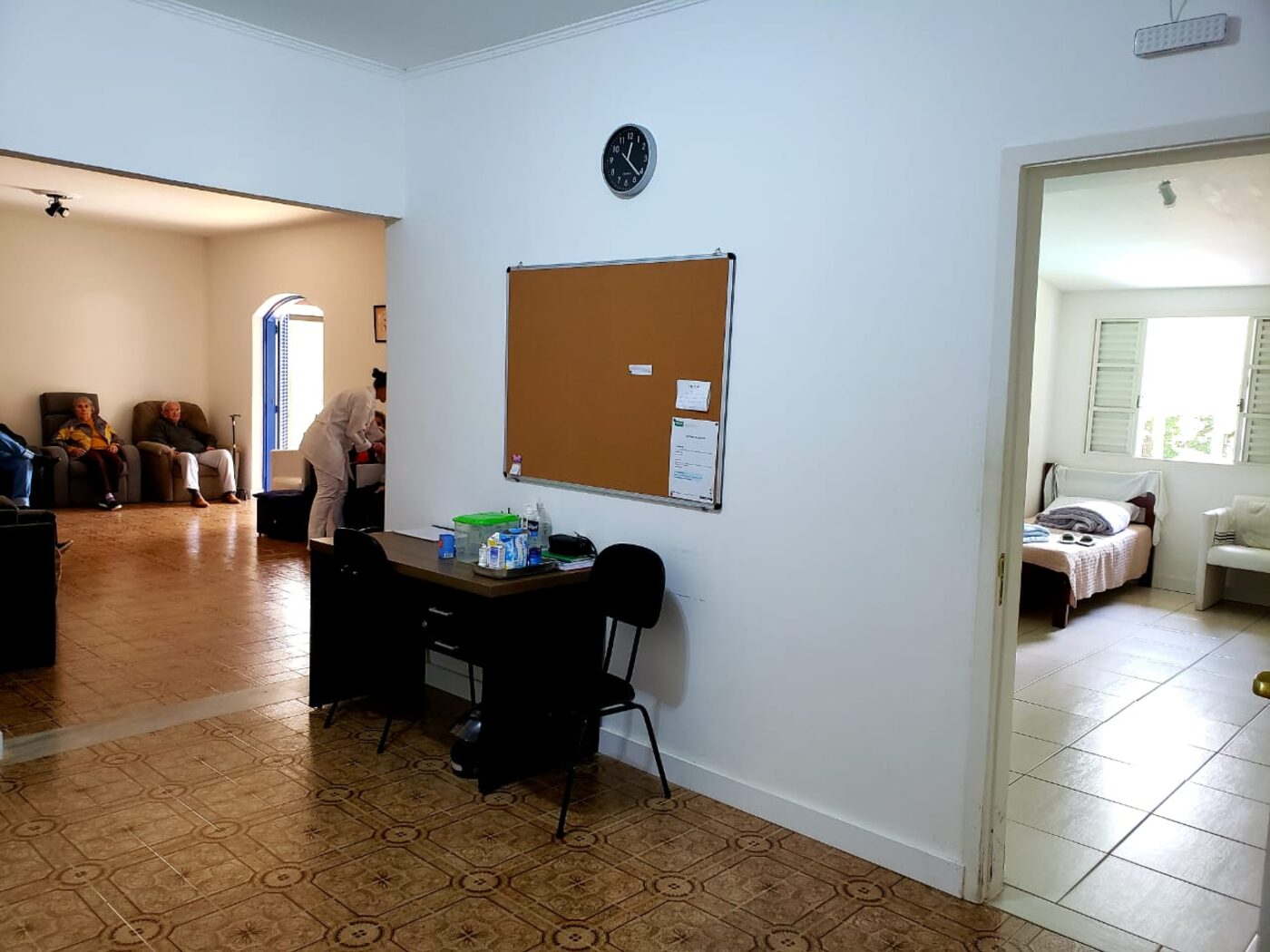 Sala de convívio da Amor de Vó, com hóspedes e equipe de enfermagem